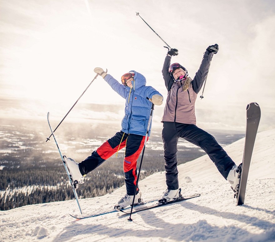 Two skiers striking a pose on top of Spring Mountain.