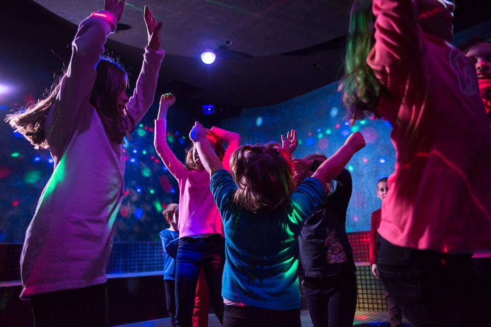 Kids dancing beneath disco lights.